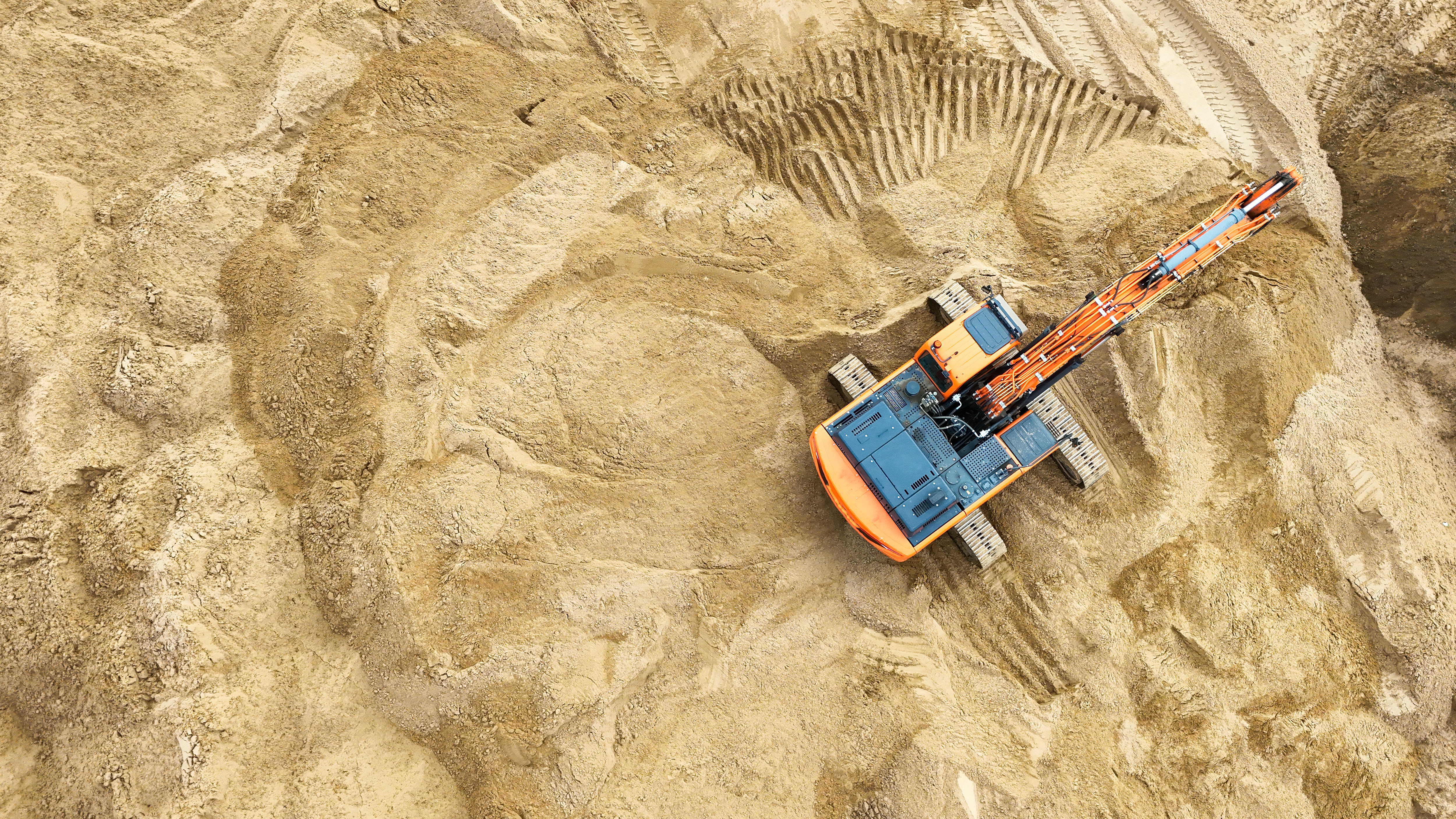 Plac budowy z koparką z lotu ptaka.