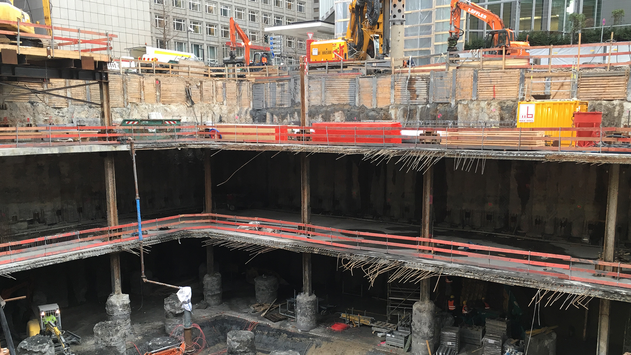Construction site with heavy machinery and deep excavation pit in Frankfurt.