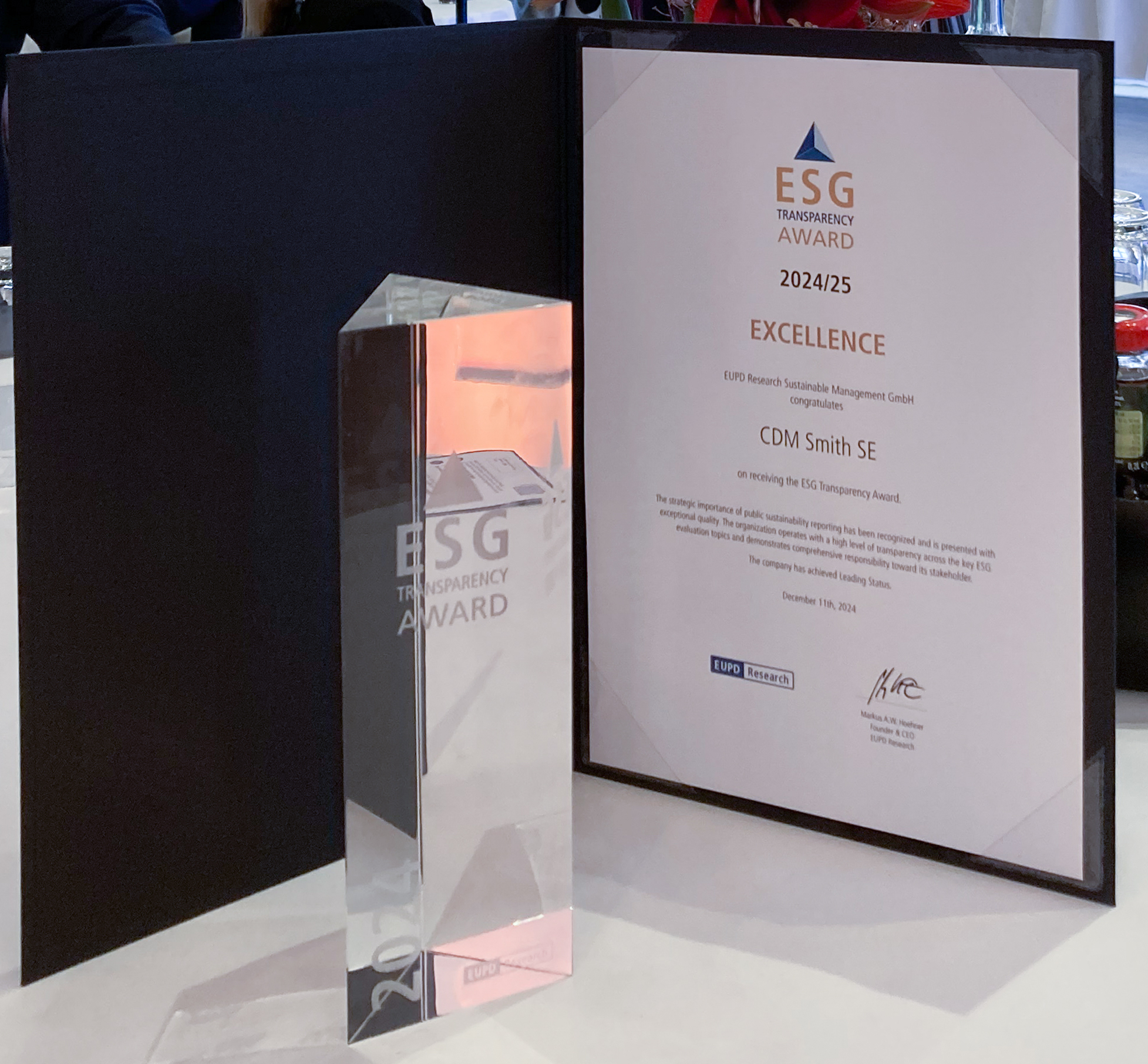 ESG Transparency Award certificate and trophy on a table at an event.