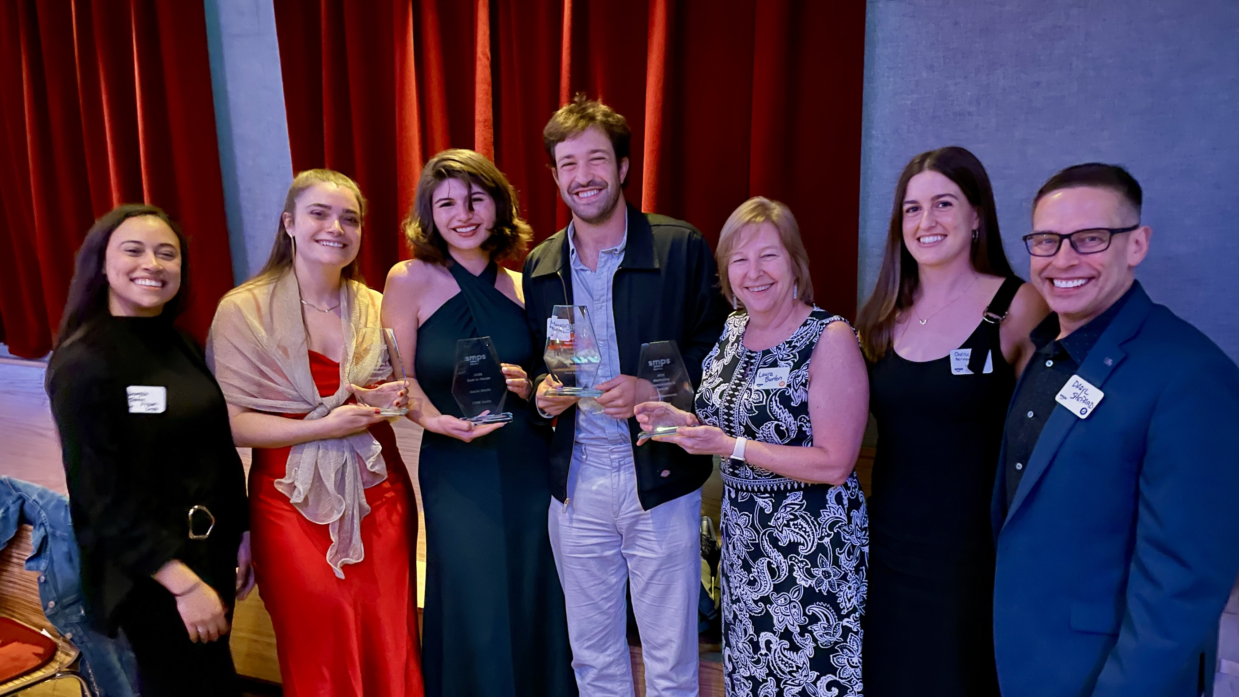7 people displaying awards at an event